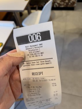 holding paper slip at McDonalds restaurant in central Basel operated by Mutti management