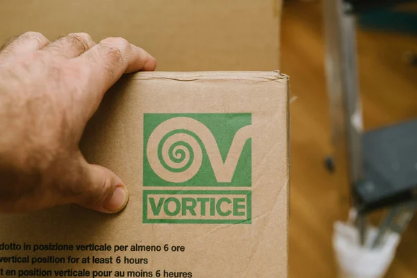 POV male hand on the cardboard package of Vortice air humidifier — стоковое фото