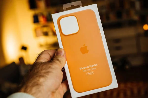 POV male hand holding orange iPhone 13 Pro silicone case with MagSafe — Stockfoto