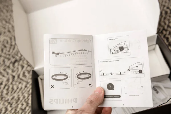 POV male hand reading manual after unboxing unpacking new Philips Signify HUE — Stock Photo, Image