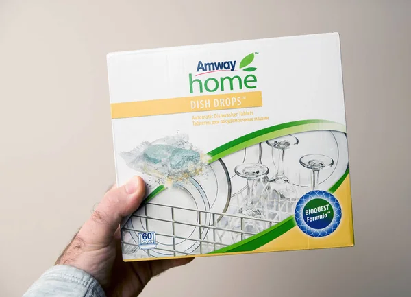 Male hand holding Amway Home Dish Drops automatic dishwasher tablets — Stock Fotó