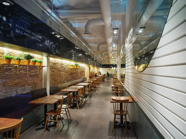 Large long empty cafe restaurant with two people inside and empty tables chairs — Stock Photo, Image