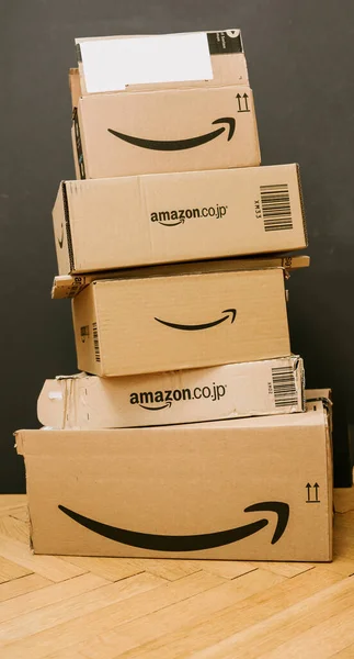 Stos z wieloma pakietami kartonowymi Amazon Prime z różnych rynków międzynarodowych, w tym Japonii — Zdjęcie stockowe