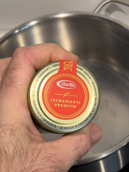 Pov erkeği elinde kaliteli Barilla makarnası olan bir şişe tutuyor.