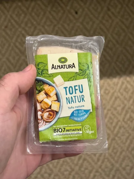 Пакет из под мужской руки с сыром Alnatura Tofu Natur — стоковое фото