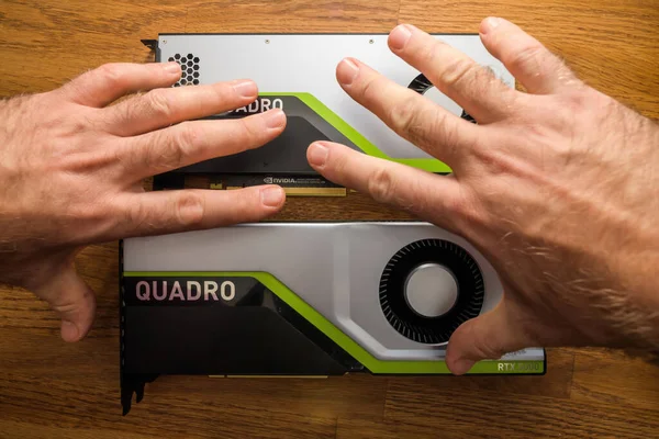 2つの新しいGPU Nvidia Quadro RTX 4000 RTX 5000を見ているシニアと若いエンジニアの手のpov保持 — ストック写真