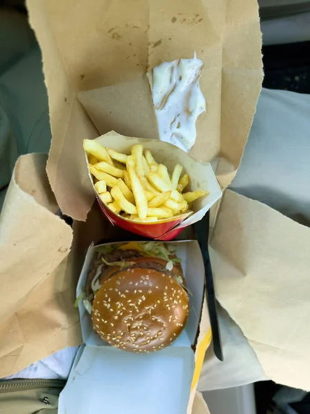 Vertical image of french fries and delicious hamburger bought in Basel McDonalds restaurant — Stock Photo, Image