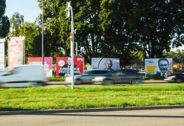 SPD 'nin şansölye adayları Olaf Scholz, CDU' nun Armin Laschet ve Bundnis 90 Die Grunen ile birlikte süratli seçim afişleriyle şehir caddesine çıkan arabalar.
