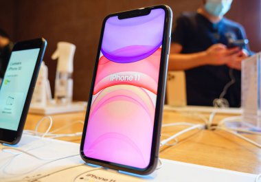 Apple Computers tarafından üretilen en son iPhone 11 'in büyük ekranında yazılıydı. Arka planda dahi bir işçi vardı.