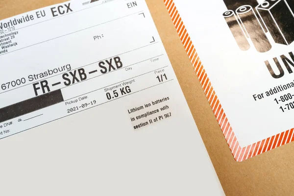 Express Worldwide EU TECH-Paket mit DHL-Logo der Syncreon-Technologie mit Warntext Lithium-Ionen-Batterien gemäß Abschnitt II der PI 967 — Stockfoto