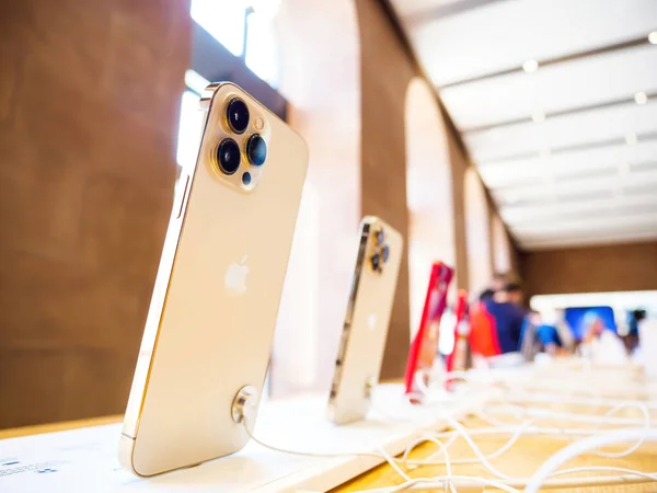 Apple Computers sklep wnętrze z rzędem nowego iPhone 13 Pro profesjonalne telefony złote kolory - tylne trzy aparat z surowego i prores wsparcie — Zdjęcie stockowe