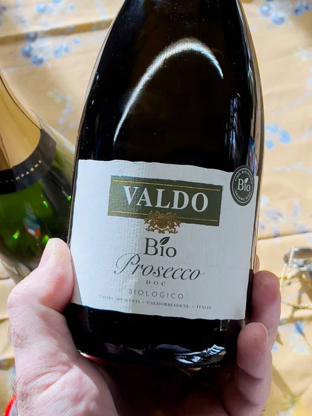 POV hane hålla flaska med Bio Prosecco tillverkning av Valdo i Italien — Stockfoto