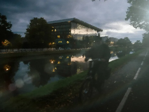 Defocused blur silhouettte of cyclist near lake in metaverse conceptual reality imagination — Stock Photo, Image