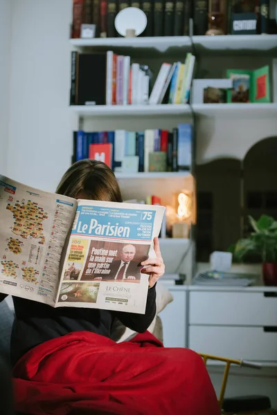 Γυναίκα διαβάζει γαλλική εφημερίδα Le Parisien με πρωτοσέλιδα Ο Ρώσος πρόεδρος Βλαντιμίρ Πούτιν — Φωτογραφία Αρχείου
