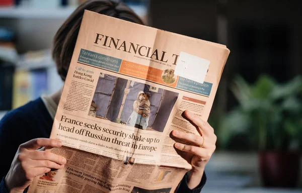 Mujer leyendo el periódico Financial Times con la foto de portada de las batallas de Hong Kong a Covid — Foto de Stock