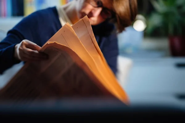 Kvinnoläsning i kvällsrummet senaste tidningen — Stockfoto