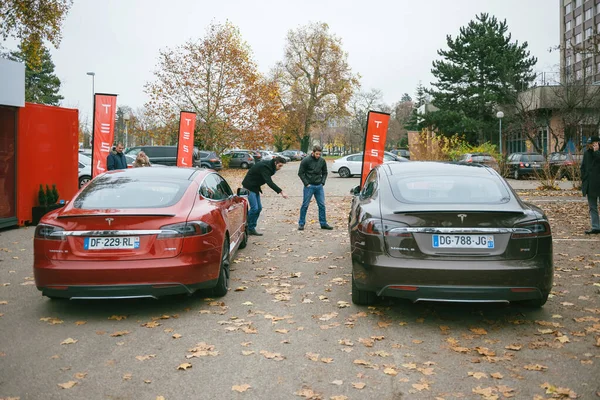 Zwei Männer beim Vergleich der neuen Elektroautos P85 und P85 plus von Tesla Motors — Stockfoto