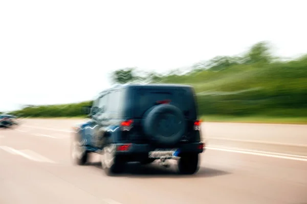 Rear view of highway with fast SUV car silhouette — Stock Photo, Image