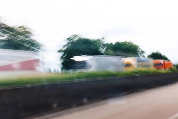 Defokussierte Unschärfe: Lastwagenreihe fährt auf Autobahn — Stockfoto