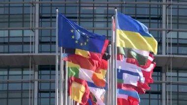 Ukrayna bayrağı Avrupa Bayrağı 'nın yanında dalgalanıyor ve bütün AB sendikası üyeleri parlamento binası önünde bayrak sallıyor. Rusya, Ukrayna 'nın büyük kentlerine büyük çaplı bir işgal başlattıktan bir hafta sonra saldırısına devam ediyor.