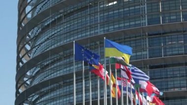 Ukrayna bayrağı Avrupa Bayrağı 'nın yanında dalgalanıyor ve bütün AB sendikası üyeleri parlamento binası önünde bayrak sallıyor. Rusya, Ukrayna 'nın büyük kentlerine büyük çaplı bir işgal başlattıktan bir hafta sonra saldırısına devam ediyor.