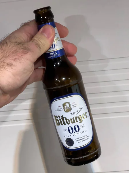POV männliche Hand hält Flasche Bitburger 0 Prozent Bier — Stockfoto