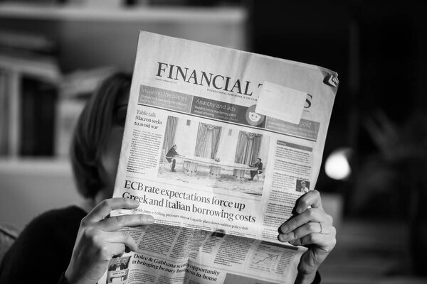 Woman reading Financial Times newspaper with the cover headline Table talk as Emmanuel Macron is meeting Russian President Vladimir Putin