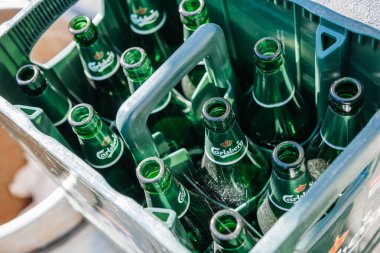 Çoklu Carlsberg 'e yakın plan. Plastik kutuda boş cam bira şişeleri.