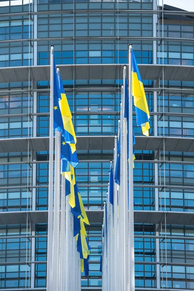 Ukrajinská vlajka vlaje vedle vlajky Evropy a všechny členské státy EU vlajky před budovou Parlamentu — Stock fotografie