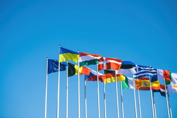 Bandera de Europa junto a la bandera de Ucrania ondea junto a toda Europa y todos los miembros del sindicato de la UE banderas con el cielo azul claro en el fondo — Foto de Stock