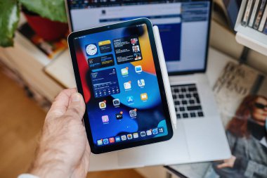 POV erkek, yeni iPad Mini profesyonelini tutuyor. Tüm uygulamaları ekranda gösteriyor.