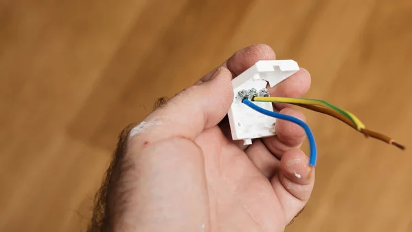 Personal perspective male hand holding during renovation reconstruction lamp installation connection — Stock Photo, Image