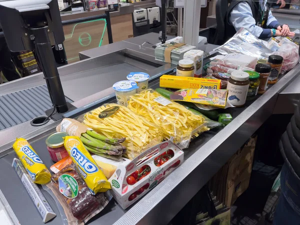 Cajero en segundo plano con múltiples dulces de alimentos frutas vegetales conserva en mostrador en el hipermercado del supermercado — Foto de Stock