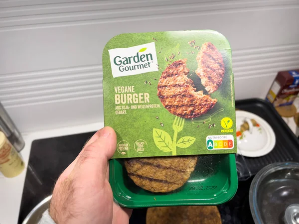 POV mano maschile che tiene la confezione con Vegan Burger prodotto da Garden Gourmet — Foto Stock