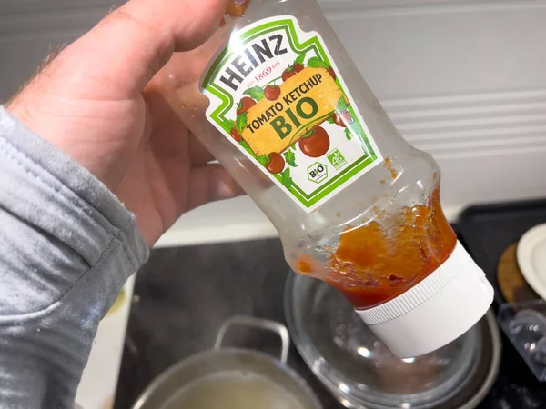 Man hand håller nästan tom flaska med Heinz Tomato Bio ketchup — Stockfoto