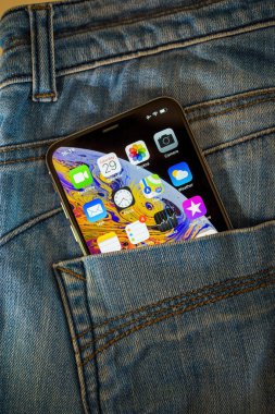 OLED retina ekranı ve ekranda birden fazla uygulama içeren yeni Apple Bilgisayarlı Akıllı Telefonun kot pantolonlarının arka cebi