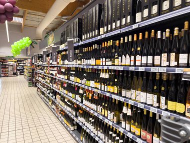 Süpermarkette şarap, alkol ve diğer alkollü içecekler satan boş bir sokak manzarası.