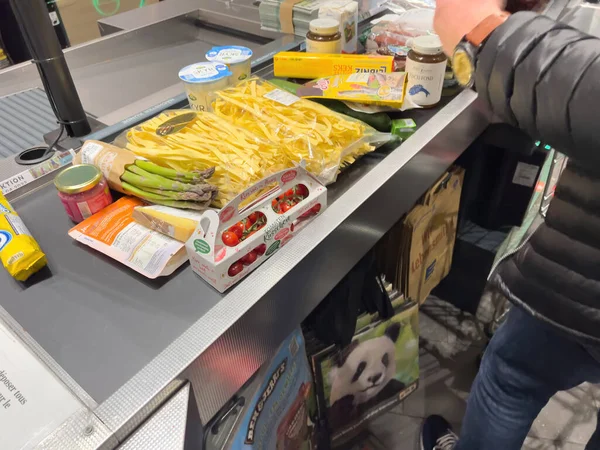 Süpermarketin hipermarketinde sebze ve meyve reçelleri düzenleyen adamın yan görünüşü