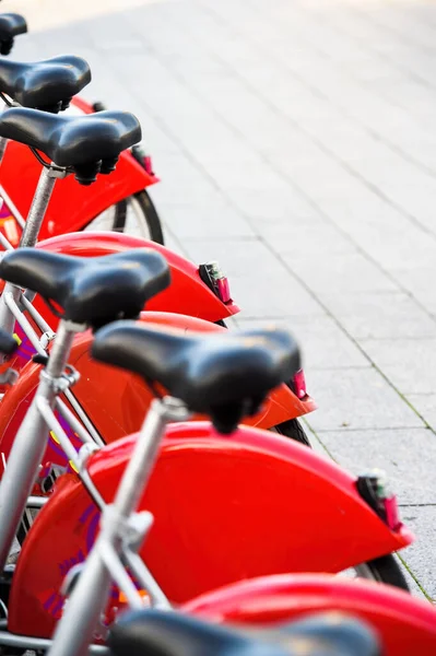 Прокат велосипедов в центре города с рядами чистых красных городских велосипедов — стоковое фото