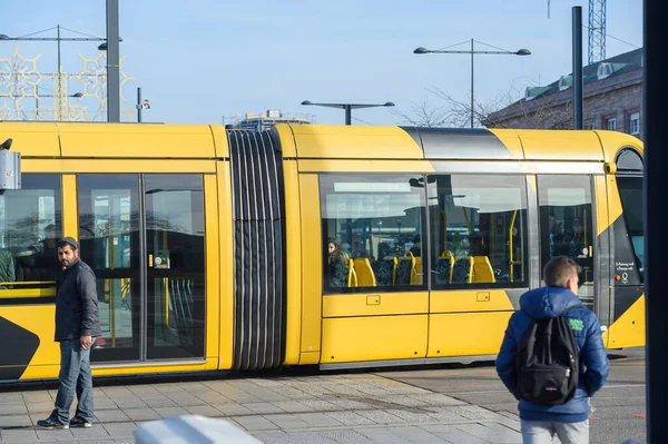 Pessoas caminhando em frente ao Tramway de Mulhouse amarelo transporte público na Place de la Gare — Fotografia de Stock