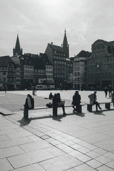 Siluetas en blanco y negro comiendo hablando descansando al aire libre en Place Kleber con la catedral de la iglesia notre-dame de Strasbourg en el fondo —  Fotos de Stock