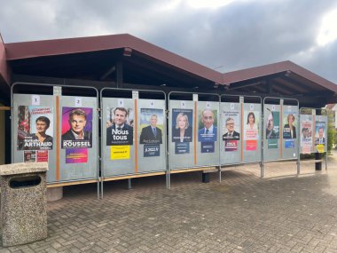 Kilstett, Alsace 'deki ana okul cephesinde 2022 başkanlık seçimleri adaylarının resmi posterleri bir sandık merkezinin yanındaki reklam panolarında sergileniyor.