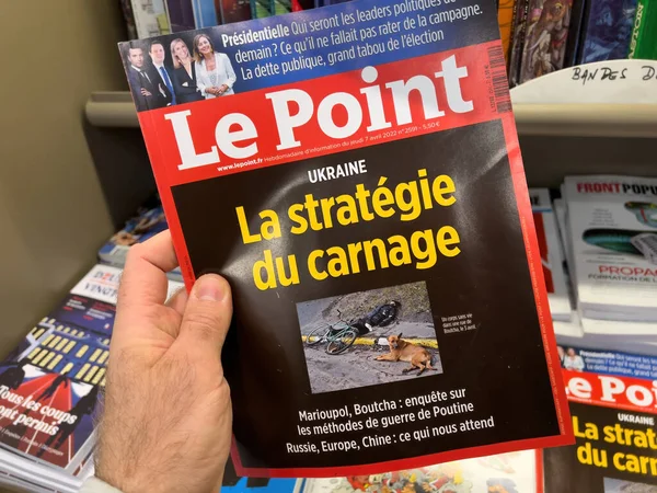 Мужчина покупает в газетном киоске Le Point международный газетный журнал с мертвым человеком на улицах Украины — стоковое фото