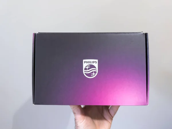 POV male hand holding new Philips Hue cardboard box - a line of color changing LED lamps and white bulbs which can be controlled wirelessly — 스톡 사진