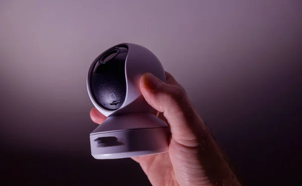 Чоловіча рука тримає сучасну крихітну 8k UHD камеру спостереження з циклопами, як об'єктив зі спеціальним слотом — стокове фото