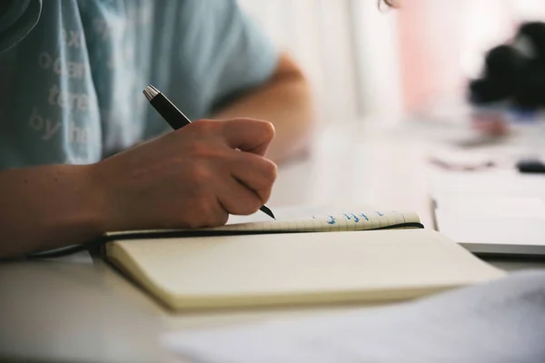 Zijaanzicht van een vrouw die een vulpen gebruikt om in haar dagboek een gedicht te schrijven — Stockfoto