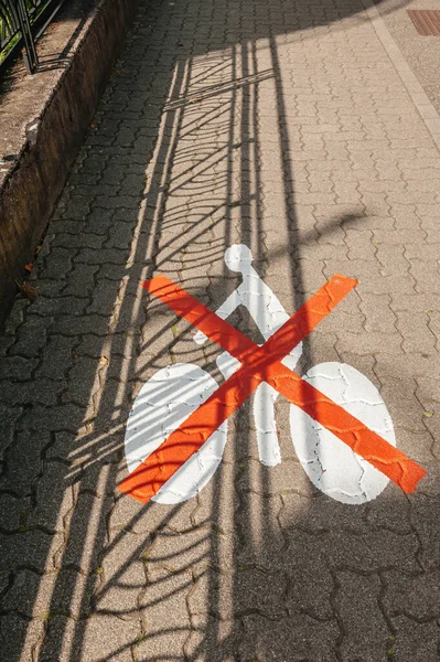 Sign on pavement road with red lines above forbidden for cycling space — Zdjęcie stockowe