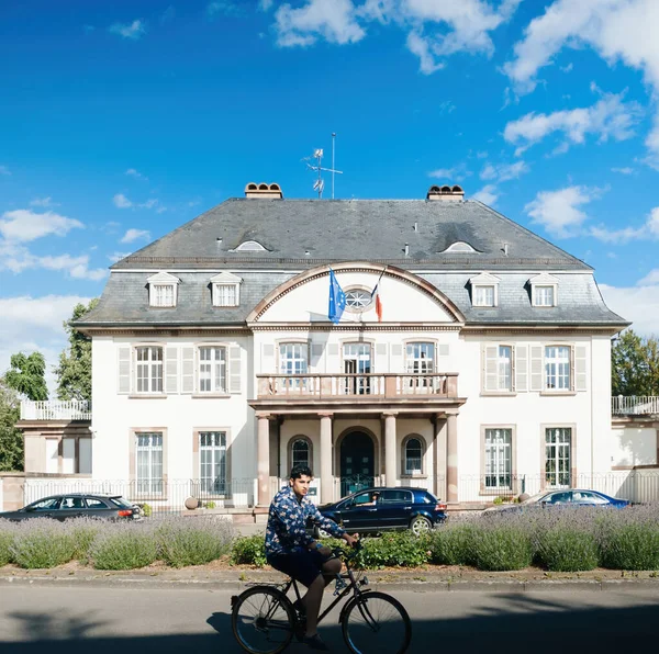 Cyclist male sightseeing in front of the historic building of Permanent representation of France to the Council of Europe — Stock Photo, Image