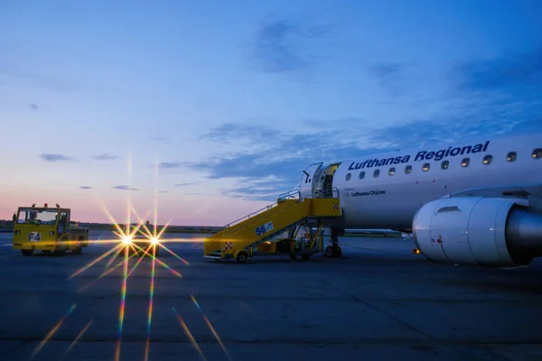 Lufthansa regional City Line plane on the tarmac ready to take off waiting for passengers at dusk morning with star filter from the parking car — Foto Stock