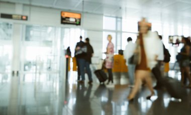 Havaalanı terminalinde yürüyen insanlar çıkış pasaport kontrolü için kapıya gidiyorlar.